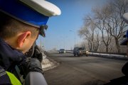 Umundurowani policjanci ruchu drogowego prowadzący pomiary prędkości.