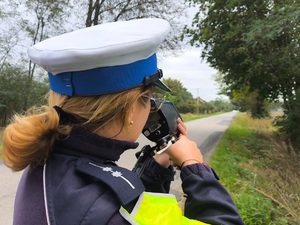 Umundurowani policjanci ruchu drogowego prowadzący pomiary prędkości.