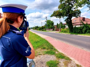Umundurowani policjanci ruchu drogowego prowadzący pomiary prędkości.