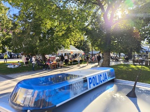 Oznakowany radiowóz a w tle uczestnicy eventu.
