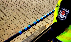 Rękaw kurtki policyjnej i odblaski na poręczy