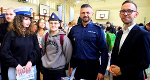 Komendant, pracownik kadr i dwie dziewczyny w czapkach policyjnych.