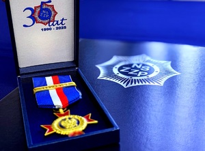 Medal w futerale obok teczka ze skrótem związku.