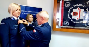 Przewodniczący związku wręcza medal policjantce.