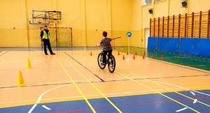 Policjant i dziecko podczas egzaminu na kartę rowerową jadące po torze przeszkód.