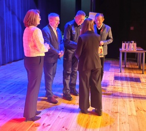 Komendant wręczający nagrodę dla zwycięscy obok inni współorganizatorzy konkursu.