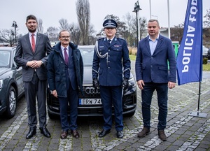Czterech mężczyzn w tym trzech przedstawicieli samorządu i komendant oraz radiowóz .