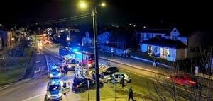 Pojazdy stojące na skrzyżowaniu po zdarzeniu drogowym, dwa radiowozy policyjne i strażackie.