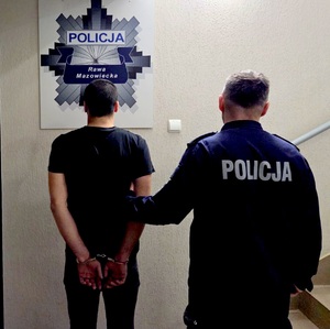 Policjant z zatrzymanym w tle gwiazda policyjna.