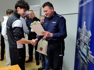 Komendant wręcza chłopcom nagrody.