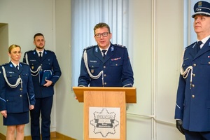 Komendant zdający obowiązki podczas przemówienia i inni policjanci.