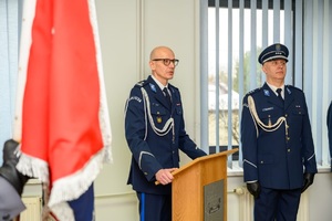 Komendant obejmujący stanowisko podczas przemówienia i inni policjanci.