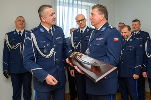Komendant Wojewódzki wręczający szablę komendantowi odchodzącemu na emeryturę.