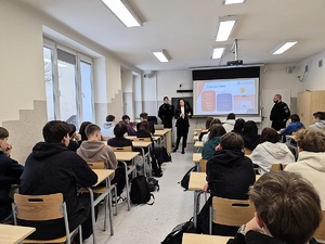 Pracownik sanepidu i policjanci stojący przed dziećmi.