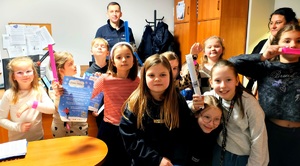 Dzieci z odblaskami oraz policjant.