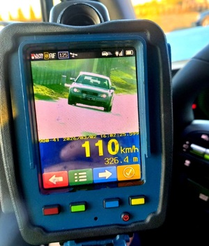 Ekran miernika prędkości gdzie widać jadący samochód i prędkość 110 kilometrów na godzinę.