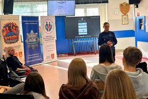 Policjantka mówi do młodzieży siedzącej przed nią.