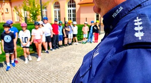 Mundur policyjny z napisem policja i dzieci w kaskach.