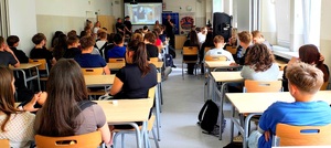 Sala gdzie młodzież siedzi w ławce i policjanci.