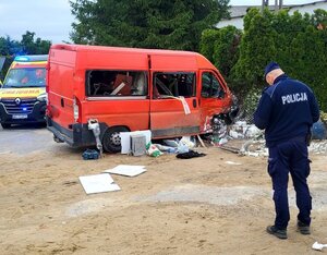 Policjant, rozbity bus i karetka.