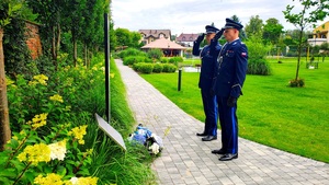 Policjanci salutujący przed tablica pamiątkową.