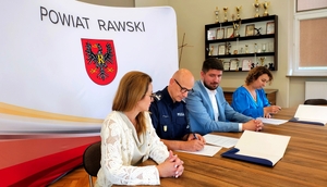 Przedstawiciele starostwa, Komendant i Dyrektorka szkoły podczas podpisywania dokumentów.