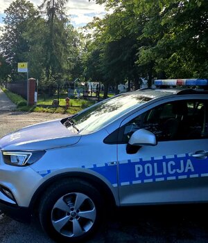 Radiowóz przy szkole, znak drogowy.