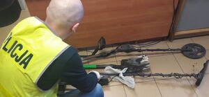 policjant z przedmiotami z poszukiwania zabytków