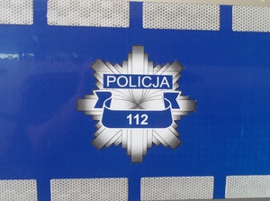 napis policja i nr 112, gwiazda policyjna na szaro-niebieskim tle