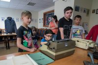 dzieci oglądające maszynę do pisania i faks