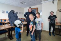 Policjant z dziećmi przymierzającymi kask policyjny