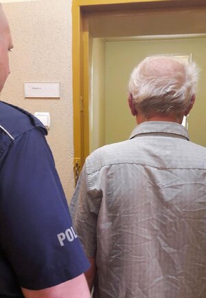 policjant prowadzi zatrzymanego mężczyznę